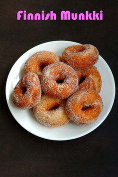 a white plate topped with sugar covered donuts