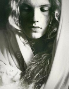 a black and white photo of a woman with her eyes closed wearing a shawl