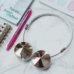 a pair of ear buds sitting on top of a table next to a spiral notebook