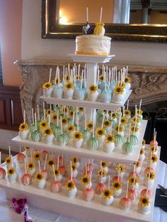 a wedding cake with sunflowers and candy on the top is displayed in front of a mirror