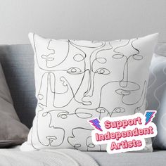 a white pillow with the words support independent artists on it in pink and blue lettering