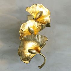 two gold flowers on a white wall