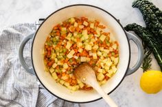 a pot filled with vegetables next to a lemon