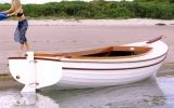 a woman standing on the end of a small boat