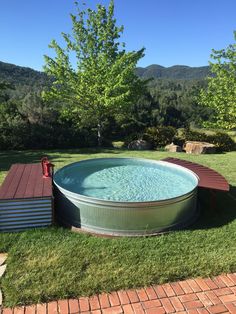 an outdoor hot tub in the middle of a lawn