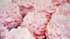 pink and white cupcakes with sprinkles on them