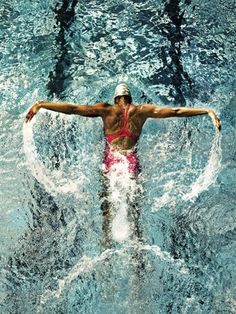 a man is swimming in the water with his arms spread out and head above the water's surface