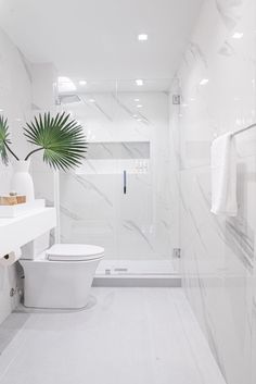 a bathroom with white walls and marble flooring, two planters on the wall