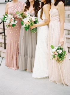 four bridesmaids are standing on the steps with their bouquets