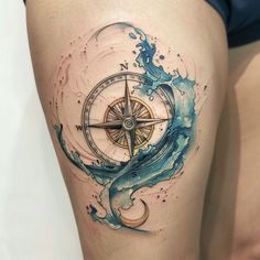 a woman's thigh with a compass and wave tattoo on her leg, watercolor style