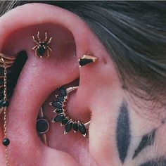 a person with tattoos on their ears and behind the ear piercings are black, gold or silver