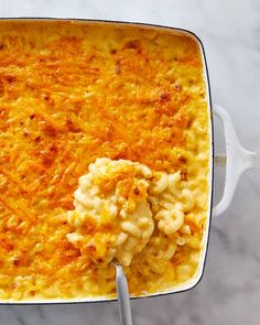 a casserole dish with macaroni and cheese in it on a marble surface