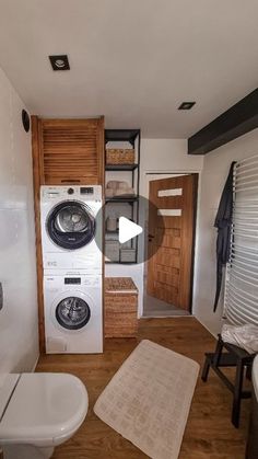 a washer and dryer sitting in a bathroom next to each other on a wooden floor