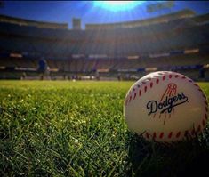 a baseball sitting on top of a lush green field next to a soccer field at a stadium