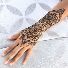 henna tattoo on the palm of someone's hand, with an intricate design