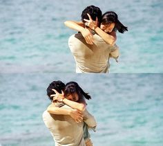 two people hugging each other on the beach