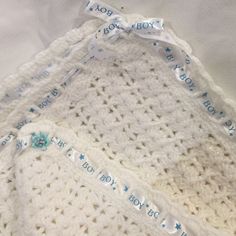 three crocheted baby blankets are laying next to each other on a white sheet