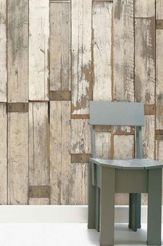 a chair sitting in front of a wall made out of wooden planks and boards