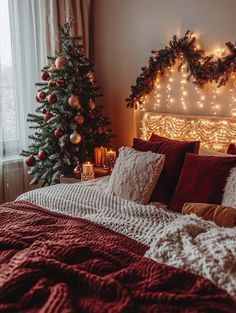 a bedroom decorated for christmas with lights on the headboard and red bed linens