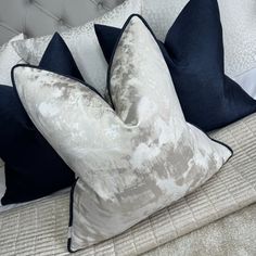 a bed with two blue and white pillows on it