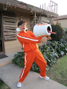 a man in an orange jumpsuit holding a white barrel