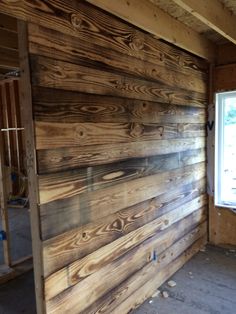 an unfinished room with wood paneling on the walls