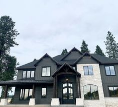 a large gray and white house with lots of windows on it's front porch