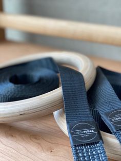 two black straps on top of a wooden table