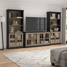 an entertainment center with bookshelves, television and couch in the living room area