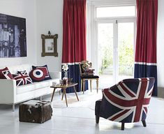 a living room with red, white and blue curtains on the windowsills is shown