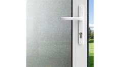 an open door with a white handle on the outside and green grass in the background