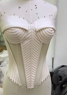 a white corset is displayed on a mannequin