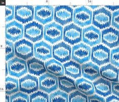 a blue and white fabric with an abstract design on it's back ground, next to a ruler