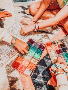 people sitting on the ground working on their laptops and crochet projects together