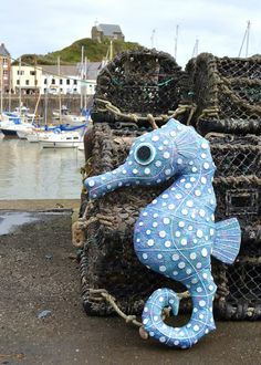 a blue sea horse sitting on top of a pile of lobster traps