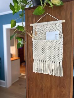 a wall hanging on the side of a wooden door next to a potted plant