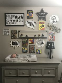 a baby is laying in his crib with many pictures on the wall