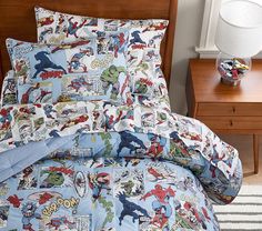 a bed covered in comic themed sheets and pillows