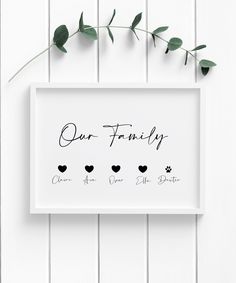 a white framed sign that says our family with hearts and paw prints on the front