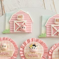 decorated cookies with farm animals on them and pink ruffles in front of a barn