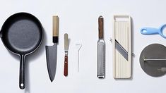 various kitchen utensils are arranged on a white surface