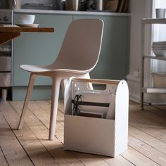 an empty chair sits on the floor next to a box with files in it