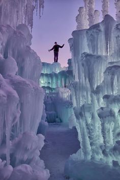 a man standing on top of ice formations