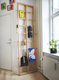 a room with a wooden ladder and various items on the shelf next to an open window