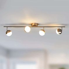 three lights are hanging from the ceiling in a room with white walls and flooring