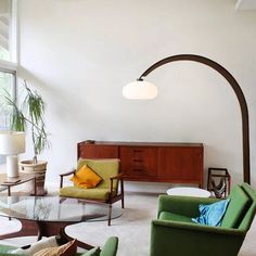 a living room filled with furniture and a large arched light over the couches in front of it