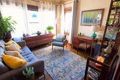 a living room filled with furniture and lots of windows