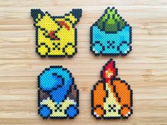 four pixelated pokemon magnets on a wooden surface