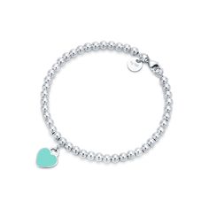 Inspired by the iconic key ring first introduced in 1969, the Return to Tiffany collection is a classic reinvented. An elegant bead bracelet and engraved tag combine to create a simple and timeless design. Sterling silver with Tiffany Blue® enamel finish; Size extra small; Fits wrists up to 5.25"; Beads, 4 mm; Instantly recognizable, the signature Tiffany Blue® hue of this design’s enamel finish has been as iconic as the brand itself since its founding in 1837 | Return to Tiffany® Tiffany Blue® Tiffany Bead Bracelet, Tiffany And Co Bracelet, Tiffany Bracelets, Return To Tiffany, Heart Tag, Silver Bead Bracelet, Tiffany And Co, Heart Beads, Blue Heart