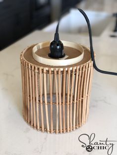 a wicker basket with a black cord attached to the handle on a counter top